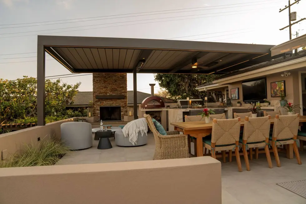 Backyard dining and lounge area with fireplace and modern black pergola with recessed lighting